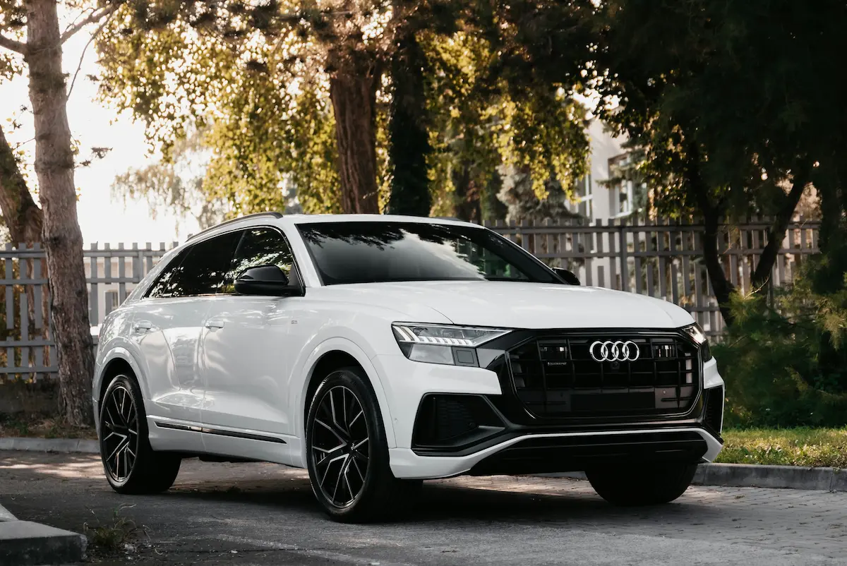 Audi car driving on a tree-lined road